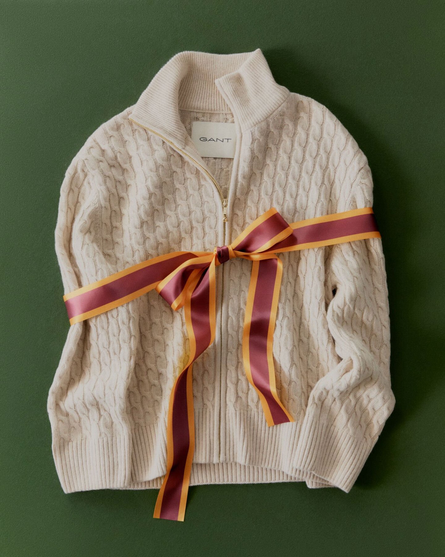 Cream womens knitwear wrapped with a red and orange ribbon